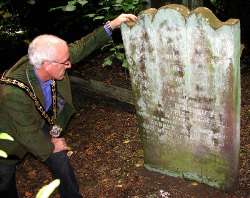 Alderman Nigel Hamilton examines the McKinney headstone.